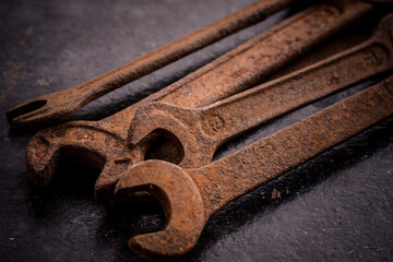 Old rusty wrenches on a dark background