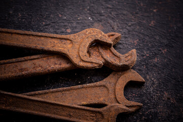 Old rusty wrenches on a dark background