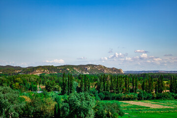 a landscape with trees and a hill in the background, in Avignon