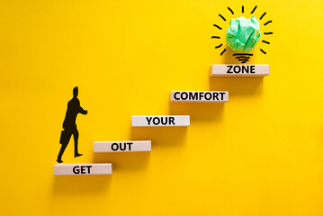 Get out your comfort zone symbol. Wooden blocks with words Get out your comfort zone on yellow...