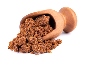 Muscovado sugar in wooden scoop, isolated on white background. Barbados sugar, khandsari or khand.