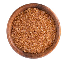 Brown sugar in wooden bowl, isolated on white background. Heap of cane sugar crystals. Top view.
