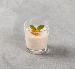 Vegan dessert, Persimmon Panna Cotta in a glass on a light gray background