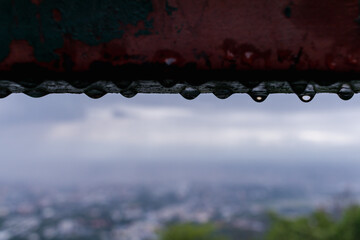 Obraz premium The water droplets on the steel beams formed by a recent rainstorm make crystal clear raindrops on the steel surface look beautiful against the blurry background of the bright rainy season nature.