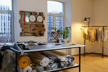 Fashion designer working studio interior with workplace table, fabric materials and sewing patterns...