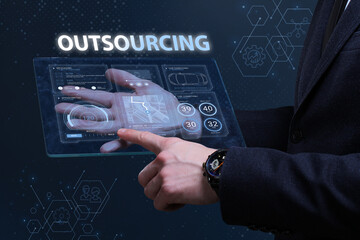 Business, Technology, Internet and network concept. Financial Graph. Stock Market chart. Young businessman working on a virtual screen of the future and sees the inscription: Outsourcing