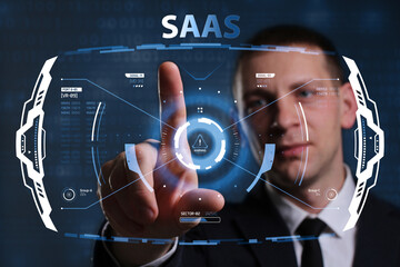 Business, Technology, Internet and network concept. Young businessman working on a virtual screen of the future and sees the inscription: SAAS