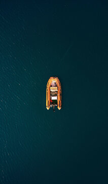 Aerial view of an orange inflatable boat moored in the Ionian Sea, Calabria, Italy.