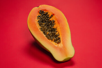 Papaya fruit on a orange background. Half papaya.