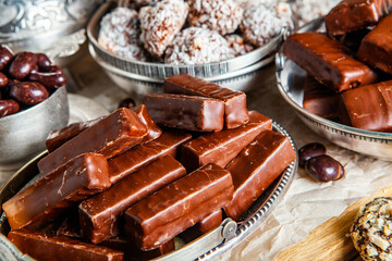 Assorted chocolate candies on wooden background. Chocolate sweets. Dessert background.