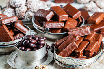 Assorted chocolate candies on wooden background. Chocolate sweets. Dessert background.