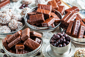 Assorted chocolate candies on wooden background. Chocolate sweets. Dessert background.