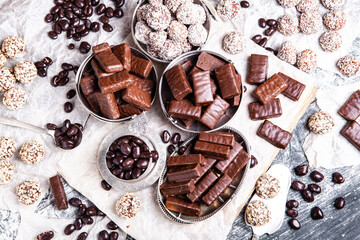Assorted chocolate candies on wooden background. Chocolate sweets. Dessert background.