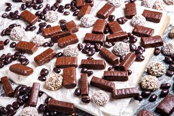 Assorted chocolate candies on wooden background. Chocolate sweets. Dessert background.