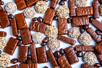 Assorted chocolate candies on wooden background. Chocolate sweets. Dessert background.