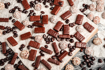 Assorted chocolate candies on wooden background. Chocolate sweets. Dessert background.