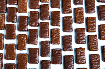 Assorted chocolate candies on wooden background. Chocolate sweets. Dessert background.