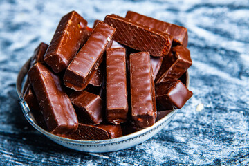 Assorted chocolate candies on wooden background. Chocolate sweets. Dessert background.