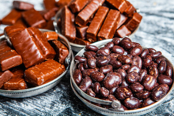 Assorted chocolate candies on wooden background. Chocolate sweets. Dessert background.
