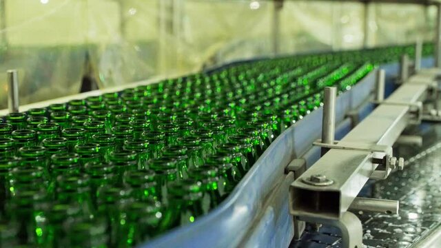 Green glass ECO Friendly bottles on conveyor belt