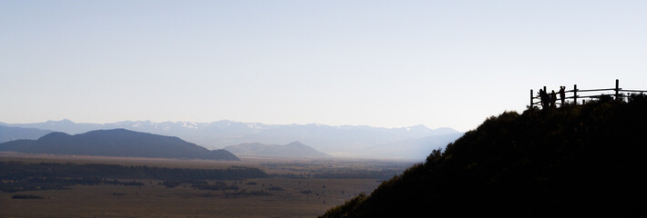 silhouette of people looking out over a valley