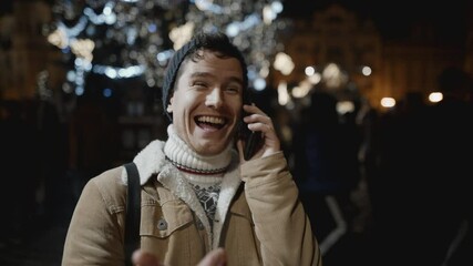 Man congratulating someone on phone at xmas night. Christmas, holiday, vacation concept. Filmed on RED camera, 10 bit clolor