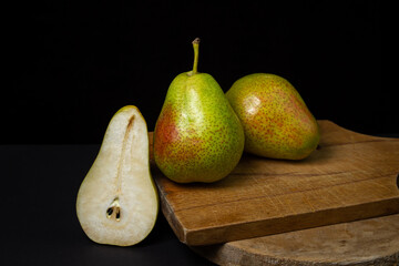 Pears on a black background. Pear cut in half. Healthy diet