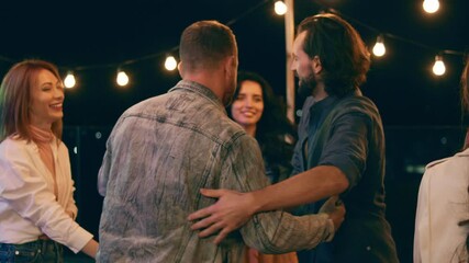 Good looking guy came to the party he say he to everyone and hugging his friends on the rooftop of terrace - Powered by Adobe
