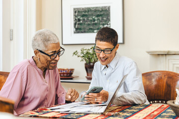 Adult daughter shows her mother something on a smartphone at home