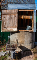village well with a roof in which there is a bucket