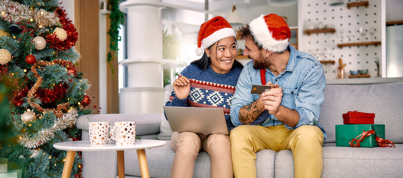 Young couple shopping online with credit card at home for Christmas