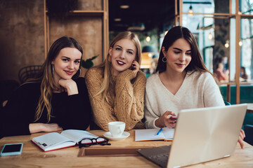 Cheerful women using laptop in cafe