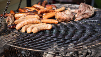 Appetizing sausages and grilled sausages in the open air. Food at mass events. City picnic.  Background with place for text.