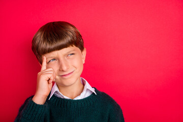 Photo of charming doubtful school boy wear knitted pullover finger temple looking empty space...