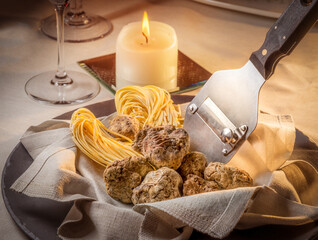 Alba white truffles in napkin with raw egg tagliolini and steel truffle cutter on the restaurant...