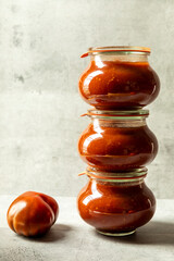 Homemade tomato puree in glass jars. Preserving own organic vegetables.