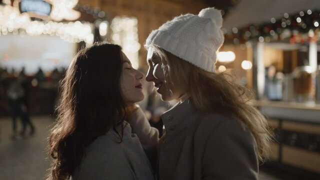 Lesbian couple in dating at xmas time. Night prague old town square. Pride, lgbt, love, friendship, christmas, holiday, vacation concept.