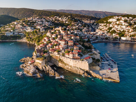 Aerial view of Ulcinj, a small town on a rocky promontory along the Mediterranean coastline in Montenegro during sunset.