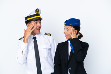Airplane pilot and mixed race air hostess isolated on white background with surprise and shocked facial expression