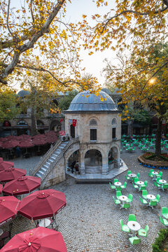 Bursa, Turkey - October 2021: Koza Han tea gardens and mosque in Koza Han Silk Bazaar. Koza Han is historical place from Ottoman times in Bursa, Turkey, and a popular tourist attraction.