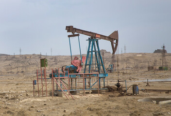 Oil and gas drilling rig onshore dessert with dramatic cloudscape . Land oil drilling rig blue sky .Land rig during the drilling operation