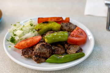 Izgara kofte, traditional Turkish meatball dish, grilled with vegetables on plate. Turkish cuisine photo