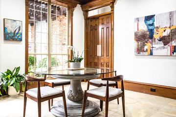 Eclectic casual dining room with glass table, wood work, high ceilings, windows