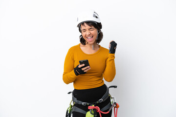 Young woman rock-climber woman isolated on white background with phone in victory position