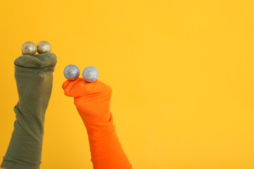 Sock puppets with baubles on yellow background
