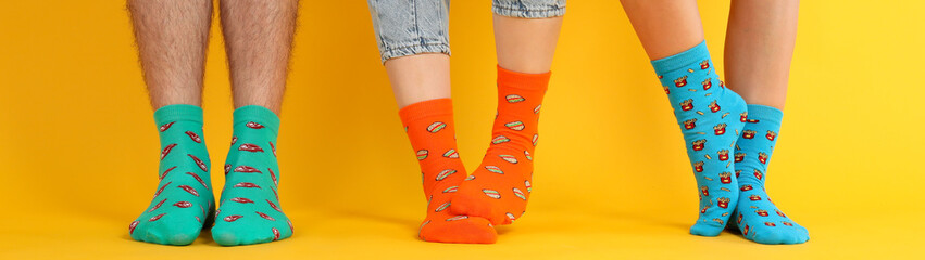 Legs in different socks on yellow background