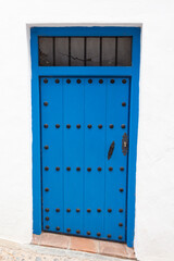 Puerta de madera azul con remaches en negro