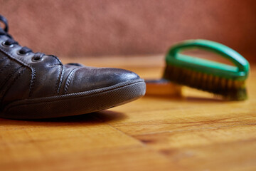 Men's leather boots and a brush and paste for shoe care.