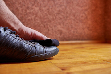 A man cleans leather shoes with a rag. Shoe care.