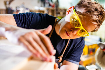 Portrait of handsome carpenter working with plank in workshop